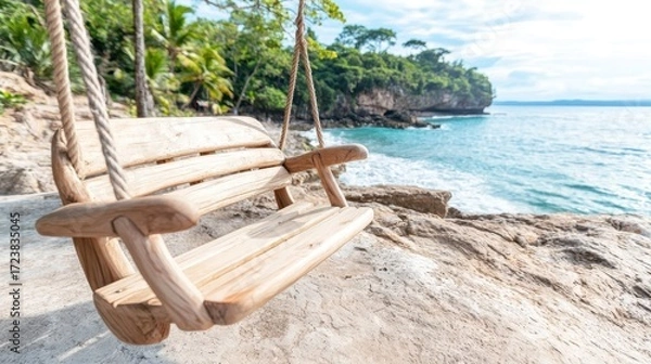 Fototapeta A serene wooden swing by the ocean, surrounded by lush greenery and the calming sound of waves, perfect for relaxation and enjoying nature.