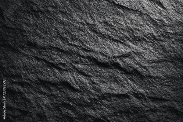 Fototapeta Dark textured slate stone surface with natural rough patterns and subtle highlights, perfect for backgrounds or design elements