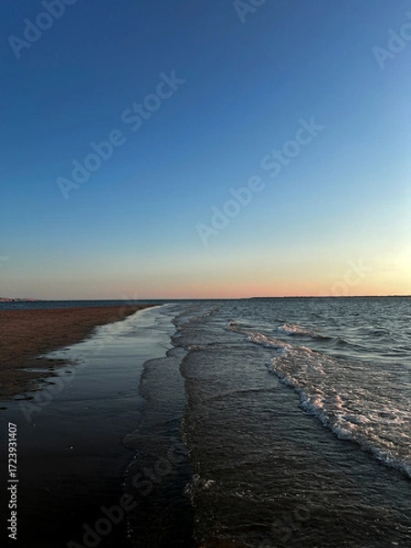 Fototapeta As the sun sets over Plage Peirere in Arcachon, golden rays reflect on the wet sand, creating a peaceful and tranquil atmosphere perfect for a calming beach walk.