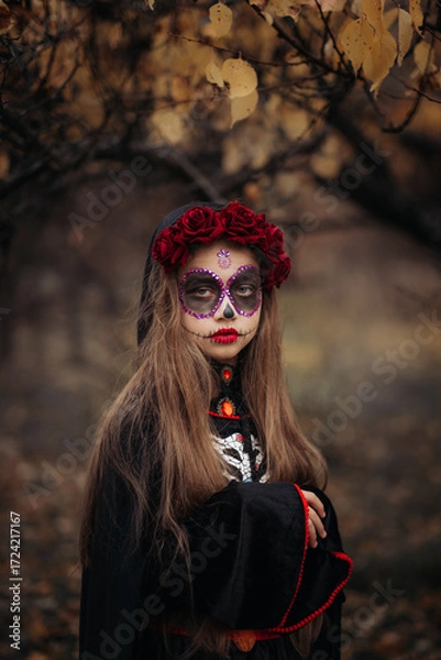 Fototapeta Witch with skull makeup in a dark forest on Halloween.