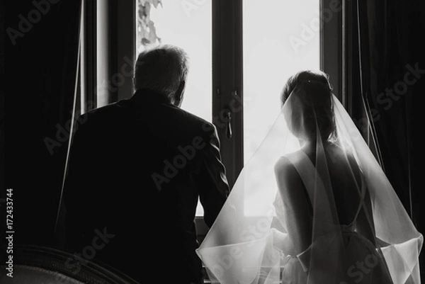 Fototapeta Bride and father of the bride looking out of a window