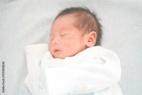 Fototapeta ベッドで眠る新生児0ヶ月の赤ちゃん