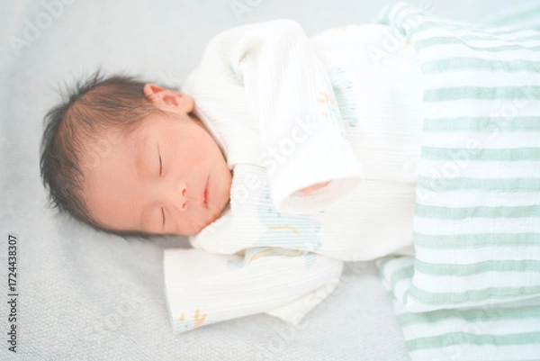 Fototapeta ベッドで眠る新生児0ヶ月の赤ちゃん