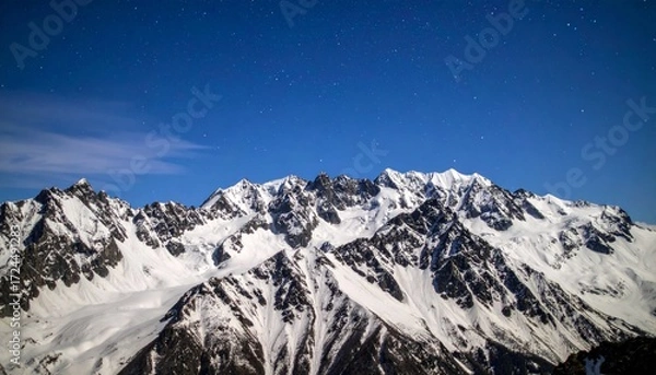 Fototapeta Celestial Serenity: Jagged Snowy Peaks Under a Deep Blue Starry Sky