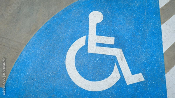 Fototapeta Wheelchair icon on road surface marking a dedicated lane for disabled access, symbolizing inclusion, accessibility, safety, and equality in urban transportation design.