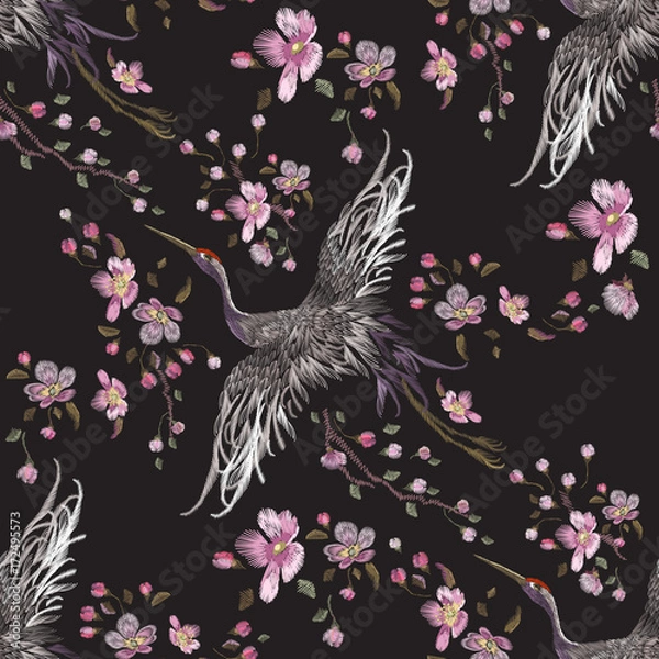 Fototapeta Embroidery oriental seamless pattern with cranes and cherry blossom. Vector embroidered floral patch with bird for clothing design.