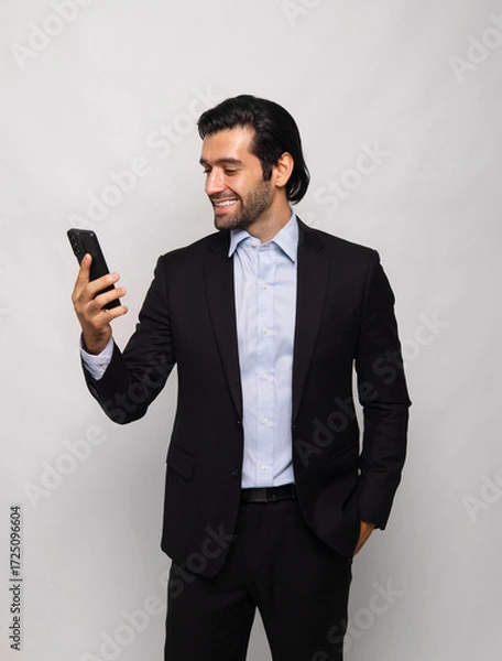 Fototapeta man in  suit is smiling and holding  cell phone