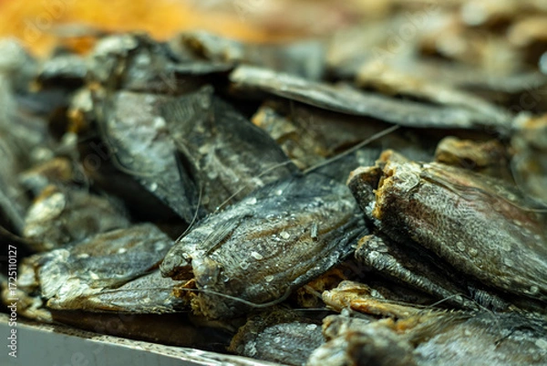 Fototapeta Close-up of dried fish stacked for sale at a traditional market, showcasing preserved seafood as a local food product and culinary ingredient