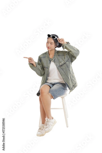 Obraz Effortless Style and Direction: A stylish figure, casually dressed in modern attire, confidently points to the side with an air of sophisticated allure.