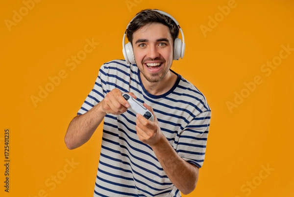 Fototapeta Excited Gamer Man Playing Online Video Game On Console With Gamepad On Yellow