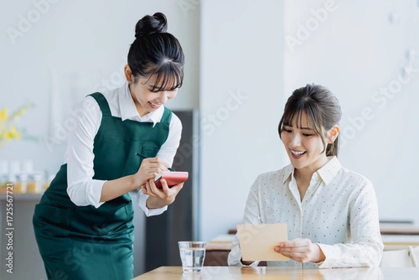 Fototapeta カフェで接客する若い女性
