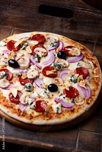 Fototapeta Pizza with chorizo ​​sausage, mozzarella cheese, and black olives. Rustic wooden background. Soft focus.	