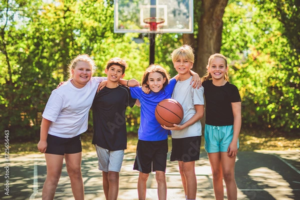 Fototapeta teens in sportswear playing basketball game outside together
