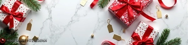 Fototapeta Festive christmas gift boxes with red ribbons on marble surface with pine branches