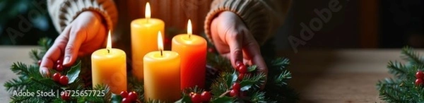 Fototapeta Female arranging candles on festive wreath with fir branches and red berries indoors