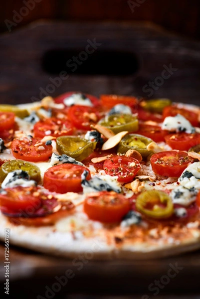 Fototapeta Pizza with salami, jalapeno pepper, cherry tomatoes and mozzarella cheese. Soft focus.	