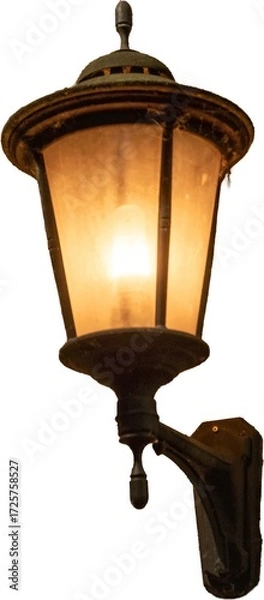Fototapeta Soft glow of an old-fashioned wall lamp illuminating a cozy outdoor area at dusk