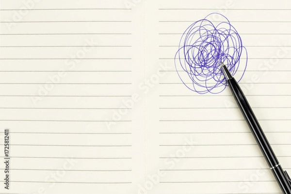 Fototapeta Concept of stress, confusion, or brainstorming with a pen making a chaotic scribble on a lined notebook.