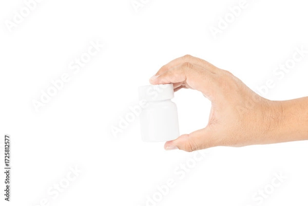 Fototapeta Hand holding a blank white plastic pill bottle for medicine or supplements, isolated on white background with clipping path.