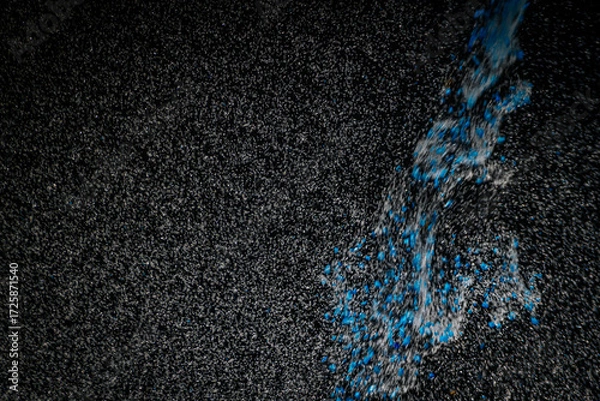 Fototapeta Abstract view of white and blue particles floating against a black background, resembling stars in space or underwater bubbles in darkness.