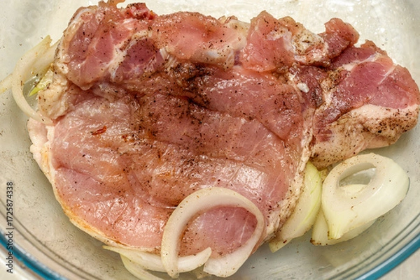 Fototapeta Raw meat marinated with onions before frying.