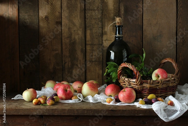Fototapeta Rustic autumn still life with  bottle. harvest of garden apples and plums.
