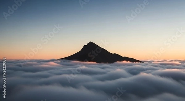 Obraz Silhouette of a pointed mountain peak above a sea of clouds at sunrise