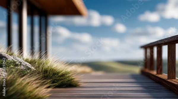 Fototapeta A tranquil outdoor scene featuring a wooden deck, lush grass, and a distant landscape under a blue sky with soft clouds.
