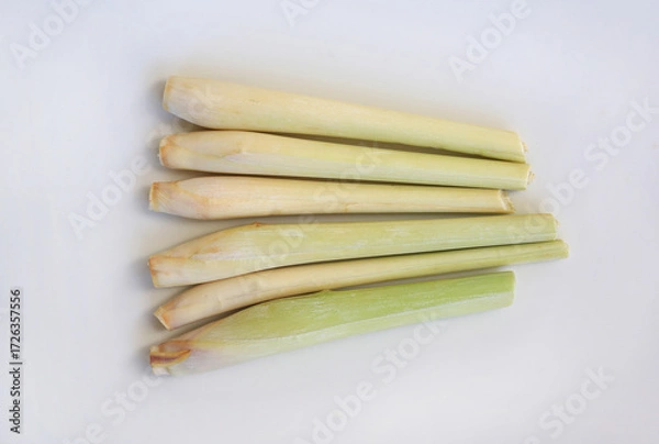Fototapeta Lemon grass against white background, preparation process of lemon grass for cooking. Top view.