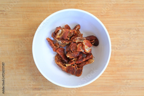 Fototapeta Peeled tamarind in white bowl on bamboo wooden background, preparation process of tamarind for cooking. Top view.