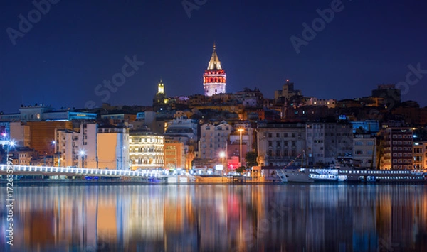 Fototapeta Galata Tower, Galata Bridge, Karakoy district and Golden Horn with motion speed light of passing ferry in the foreground at night istanbul - Turkey  