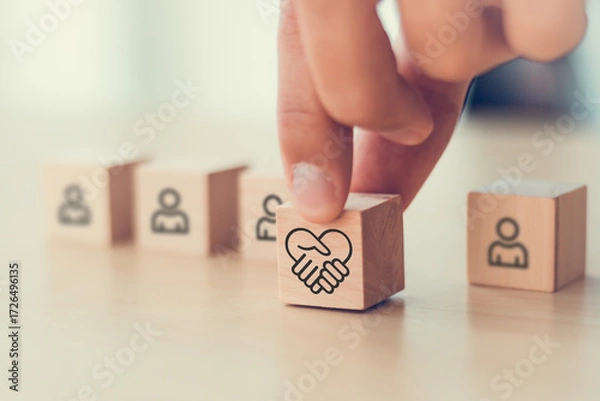 Fototapeta Empathy in leadership concept. Wooden block symbolizing empathy and partnership among blocks representing individuals, emotional intelligence and trust in workplace leadership and team collaboration.