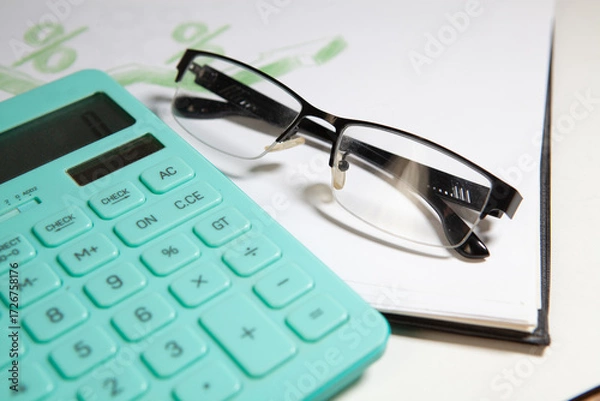 Fototapeta calculator and glasses on a white background, business still life