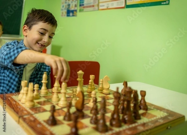 Fototapeta Young caucasian boys enjoying a chess game in classroom setting