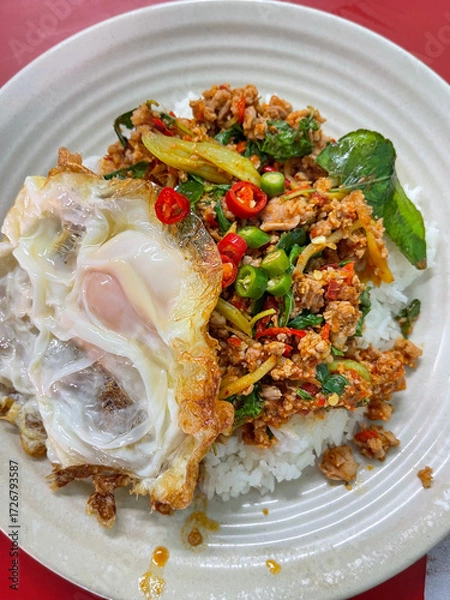 Fototapeta Rice topped with stir-fried pork and basil, Rice topped with stir fried minced pork and basil with Fried egg