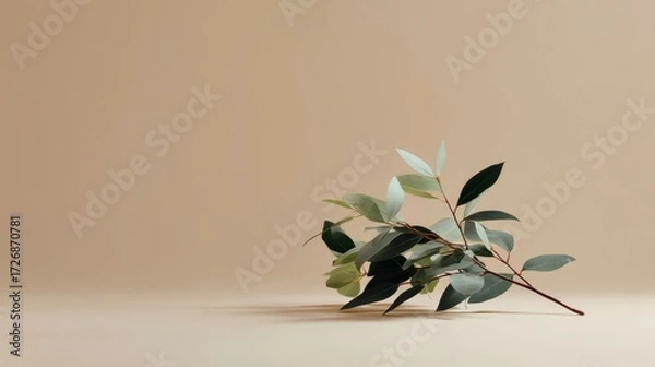 Fototapeta Elegant side view of a delicate branch with lush green leaves on a neutral textured background, creating a calm and natural atmosphere with ample space for text