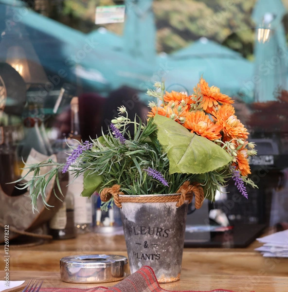 Fototapeta A bouquet of autumn flowers and reflections in the restaurant window.