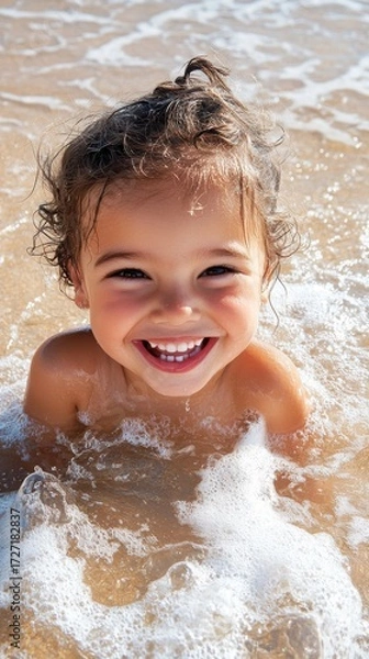 Fototapeta Joyful child portrait on sandy beach, sunlit waves glowing in background, natural beauty and sharp details highlight pure happiness.