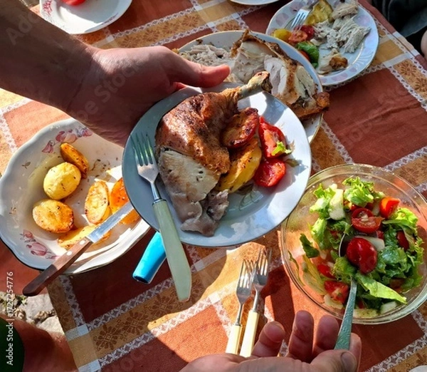 Fototapeta Meat and vegetables. One person holds a plate with roasted chicken and vegetables in their hands.