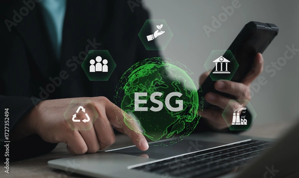 Fototapeta Business professional using digital ESG icons on laptop and smartphone, symbolizing sustainability, environmental responsibility, social impact, governance, and eco-friendly corporate strategy.