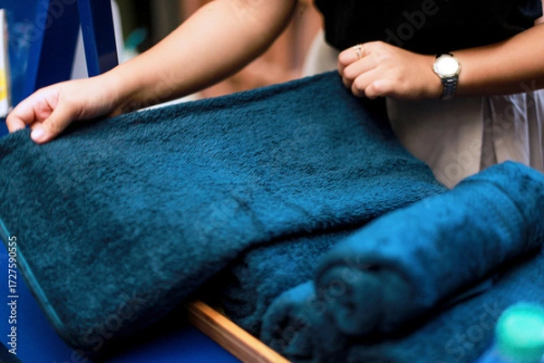 Obraz close up of hands rolling up a towel