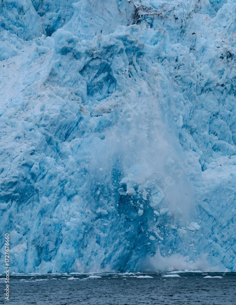 Fototapeta Close-up of the collapse of a massive segment of ice of the Aiakal Glacier as it tumbles to the sea