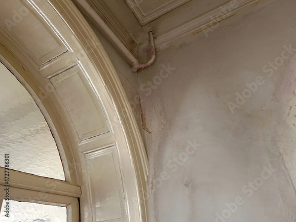 Fototapeta old welded open water pipe in a villa with damaged walls,