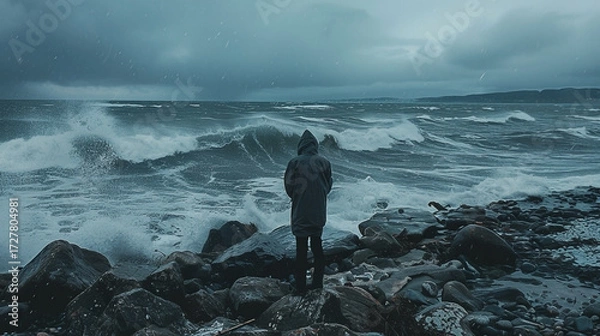 Obraz Stormy ocean scene; lone figure on rocky shore