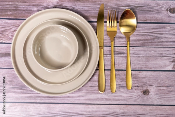 Fototapeta Empty plates, knife and fork over wooden table background. View from top with copy space.lose weight illustrated with an empty plate.