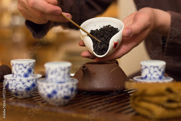 Fototapeta Chahe with black tea for Chinese tea drinking in the hands of the master over the table. Traditional Chinese tea drinking ceremony.