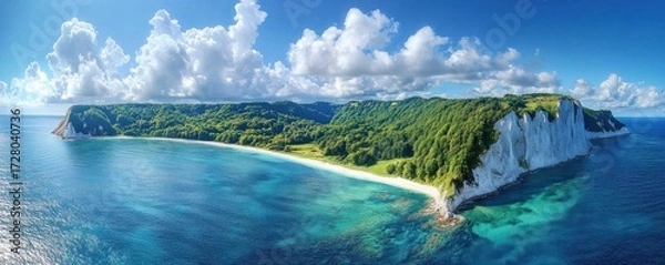 Fototapeta Panoramic view of a lush green island with white cliffs surrounded by clear blue ocean under a bright sky filled with fluffy clouds