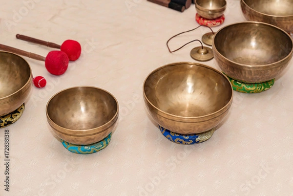 Fototapeta Group of Tibetan singing bowls arranged and ready for relaxation and yoga or meditation practice.