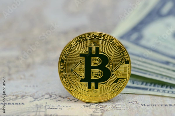 Fototapeta Golden Bitcoins on banknotes background.Photo of golden bitcoin (new virtual currency)
