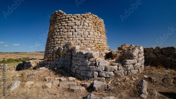 Fototapeta Nuraghe Piscu megalithic stone tower ruins in Suelli, Sardinia, under clear blue sky